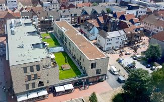 Bird's eye view onto a green roof with lawn in the city